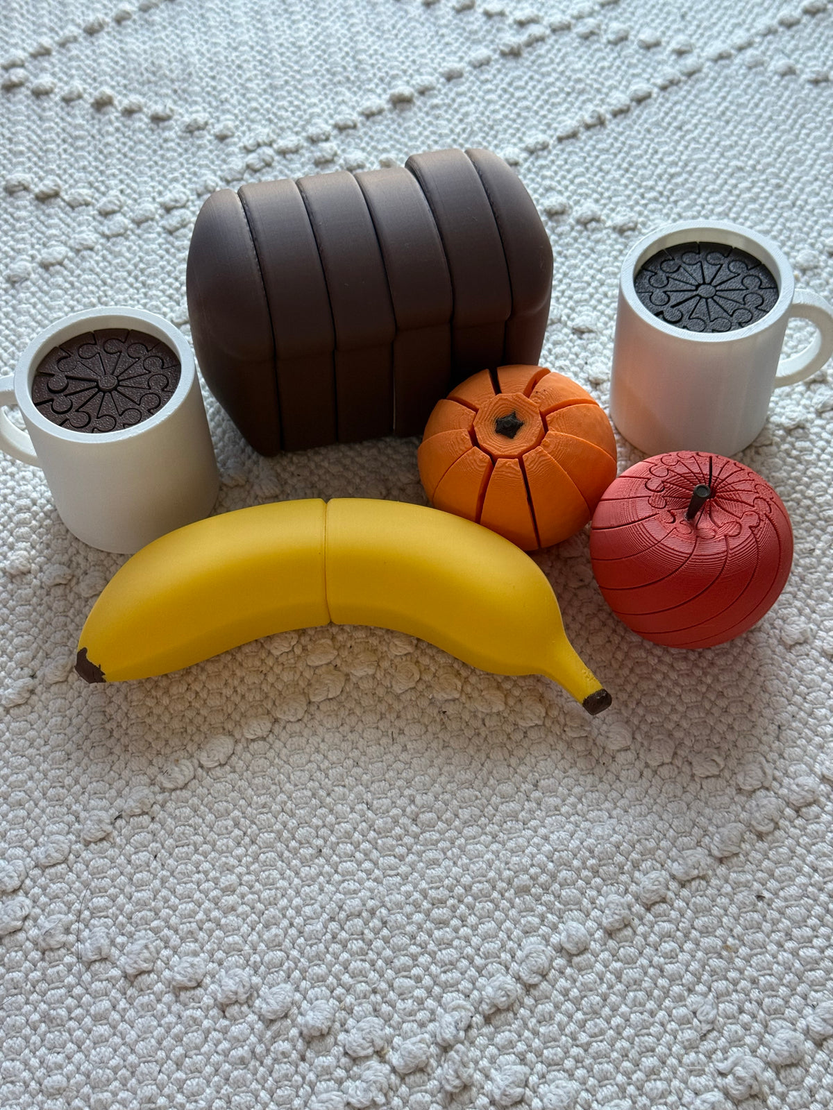 Yellow pretend-play banana styled with toy bread, fruit and coffee cups, sold separately