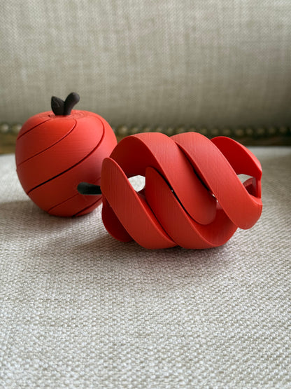 Apple fidget toy shown in its rounded and expanded spiral positions