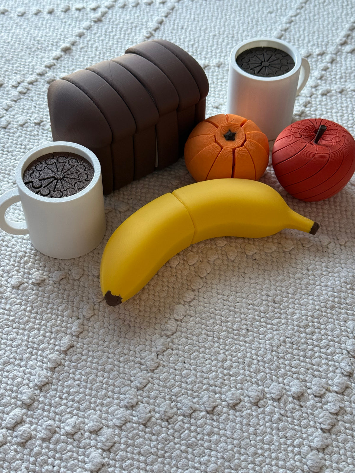 Curved yellow play banana with dark tips alongside other pretend-play food