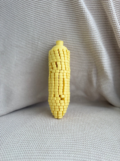 Yellow Twisty Corn standing upright on textured fabric